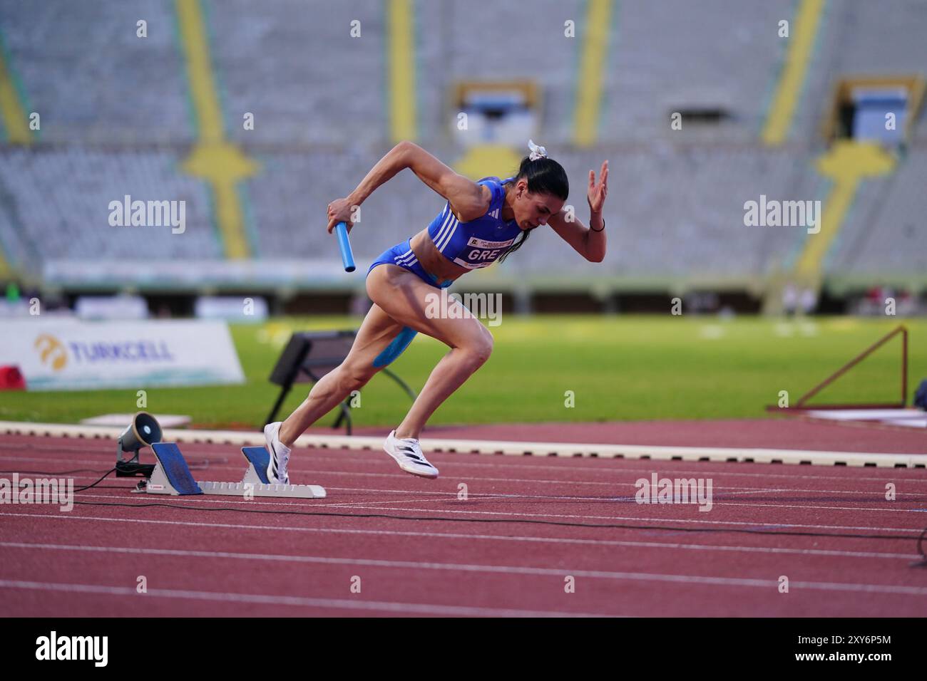 IZMIR, TURKIYE - 25 MAGGIO 2024: Atleta indefinito che corre 4x400 metri a staffetta durante i Campionati balcanici di atletica leggera allo Stadio Ataturk di Izmir Foto Stock