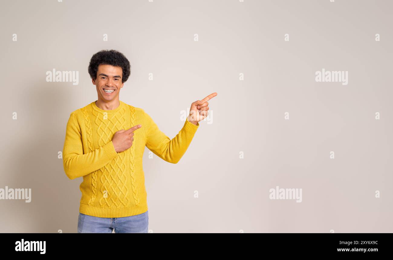 Venditore sorridente che punta allo spazio di copia e pubblicizza il nuovo prodotto su sfondo bianco isolato Foto Stock