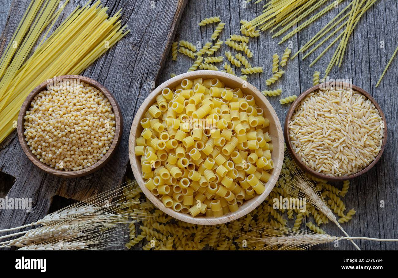 Pasta cruda varia con tagliere su fondo in pietra, concetto di cibo crudo Foto Stock