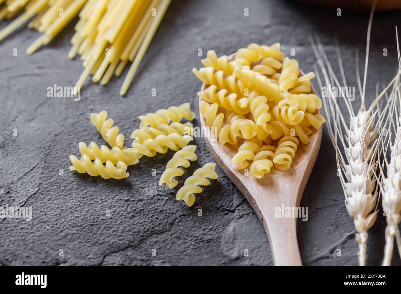 Pasta cruda con trivella in recipiente o cucchiaio, fusilli crudi con grano Foto Stock