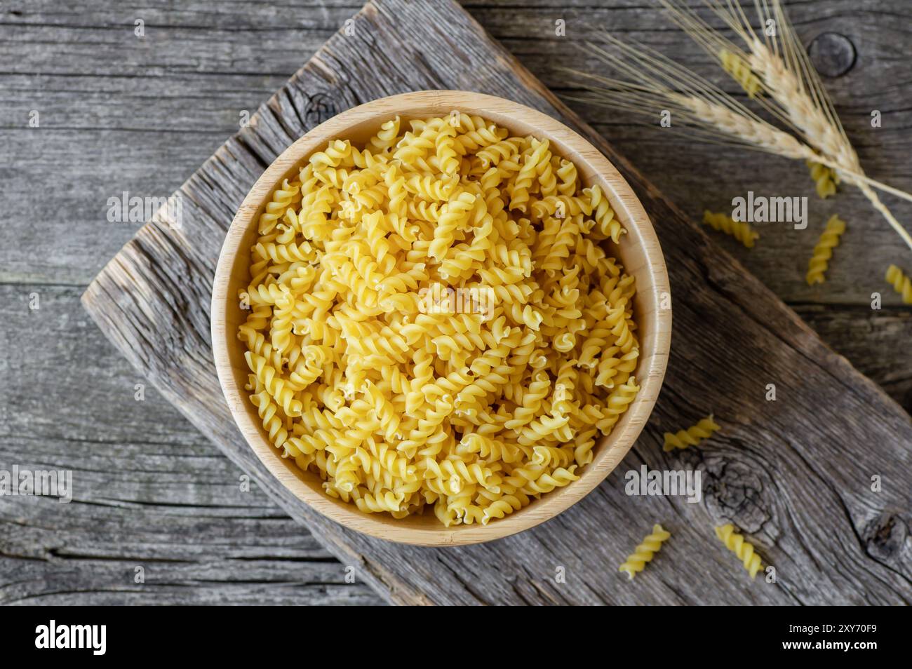 Pasta cruda con trivella in recipiente o cucchiaio, fusilli crudi con grano Foto Stock