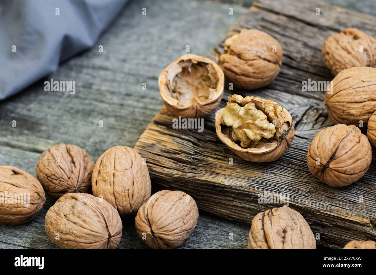 Nocciola intera matura e cruda di noce con guscio su sfondo rustico. cibo sano per noci per il cervello Foto Stock