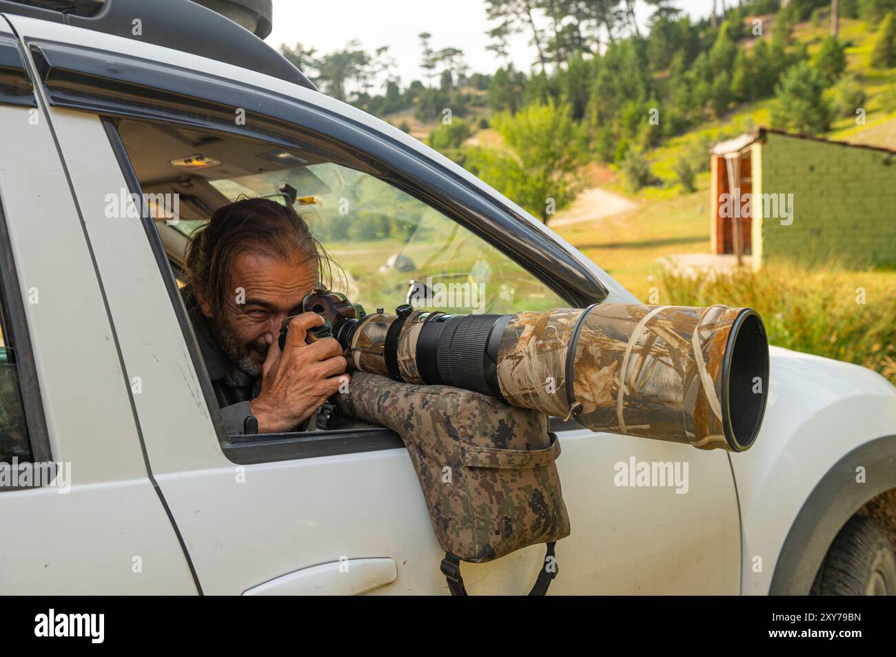 Fotografo di fauna selvatica all'aperto. Fotografo professionista in natura. Fotografo di fauna selvatica seduto in auto Foto Stock