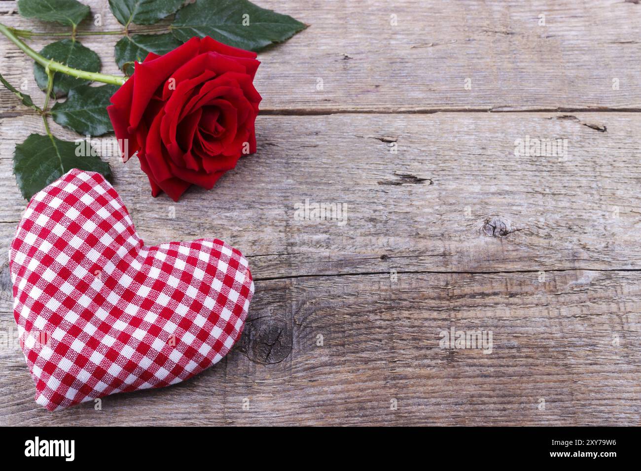 Cuore e rosa in tessuto fatti a mano su un tavolo in legno Foto Stock