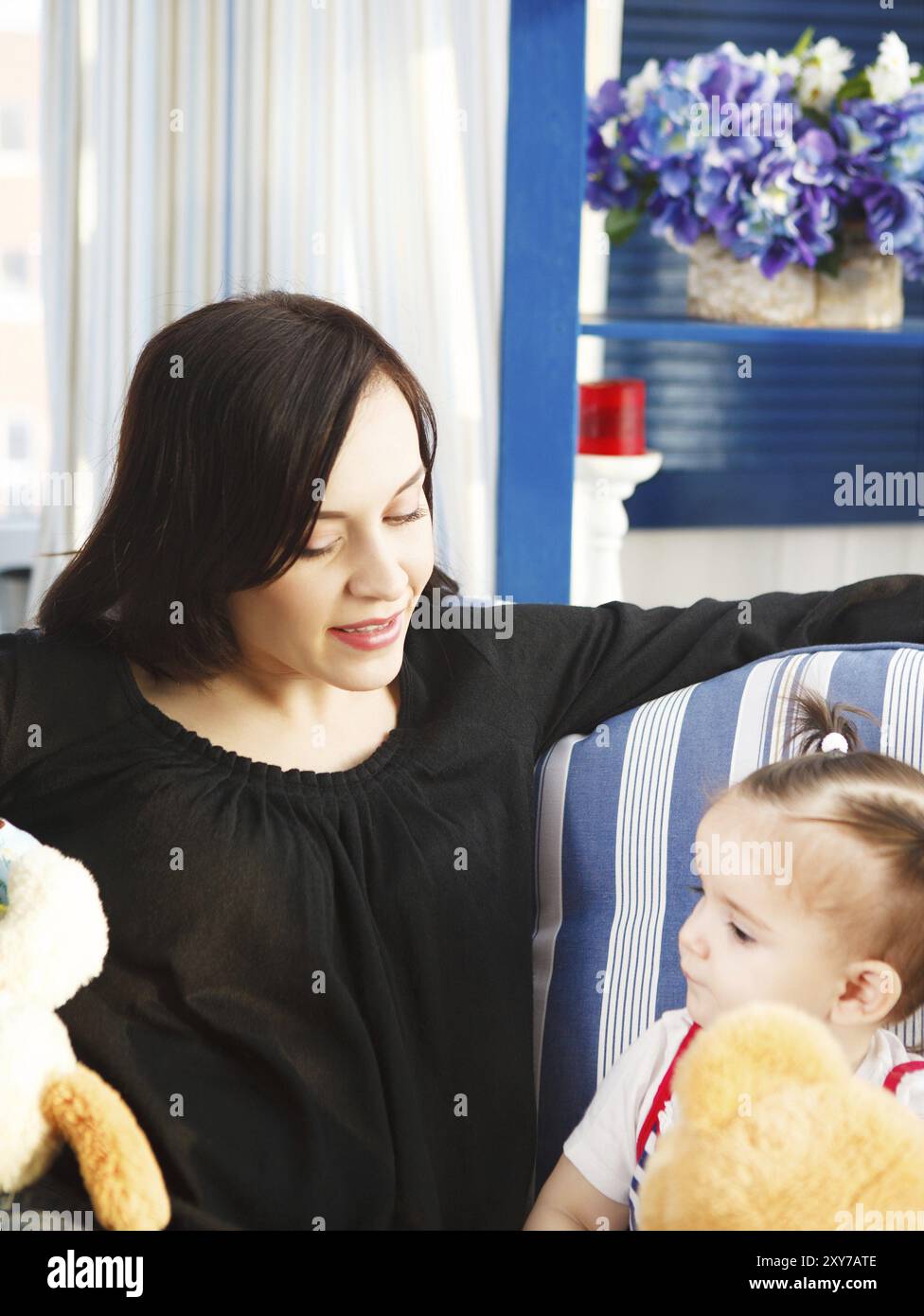 Sorridenti madre con un anno di età bambina indoor Foto Stock