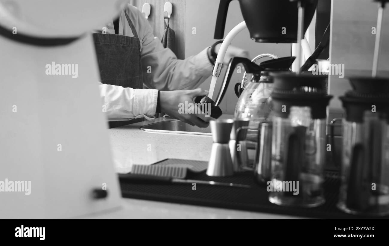 Primo piano dell'americano che viene versato dalla macchina per il caffè in una tazza. Caffè professionale per la preparazione di caffè nero. Macchina espresso professionale Foto Stock