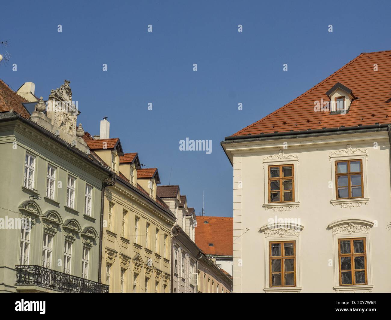 Facciate di edifici storici con tetti di tegole rosse e finestre ornate sotto un cielo limpido, Bratislava, Slovacchia, Europa Foto Stock