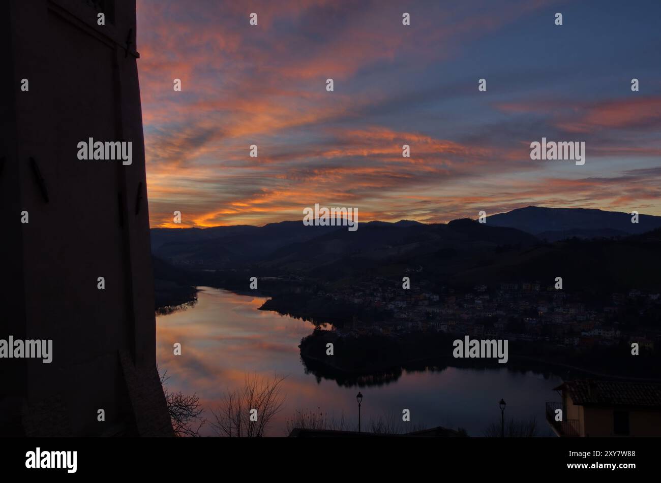 Panorama del lago di Mercatale, visto dalla piazza dell'orologio del paese di Sassocorvaro, contro un cielo scenografico al tramonto Foto Stock