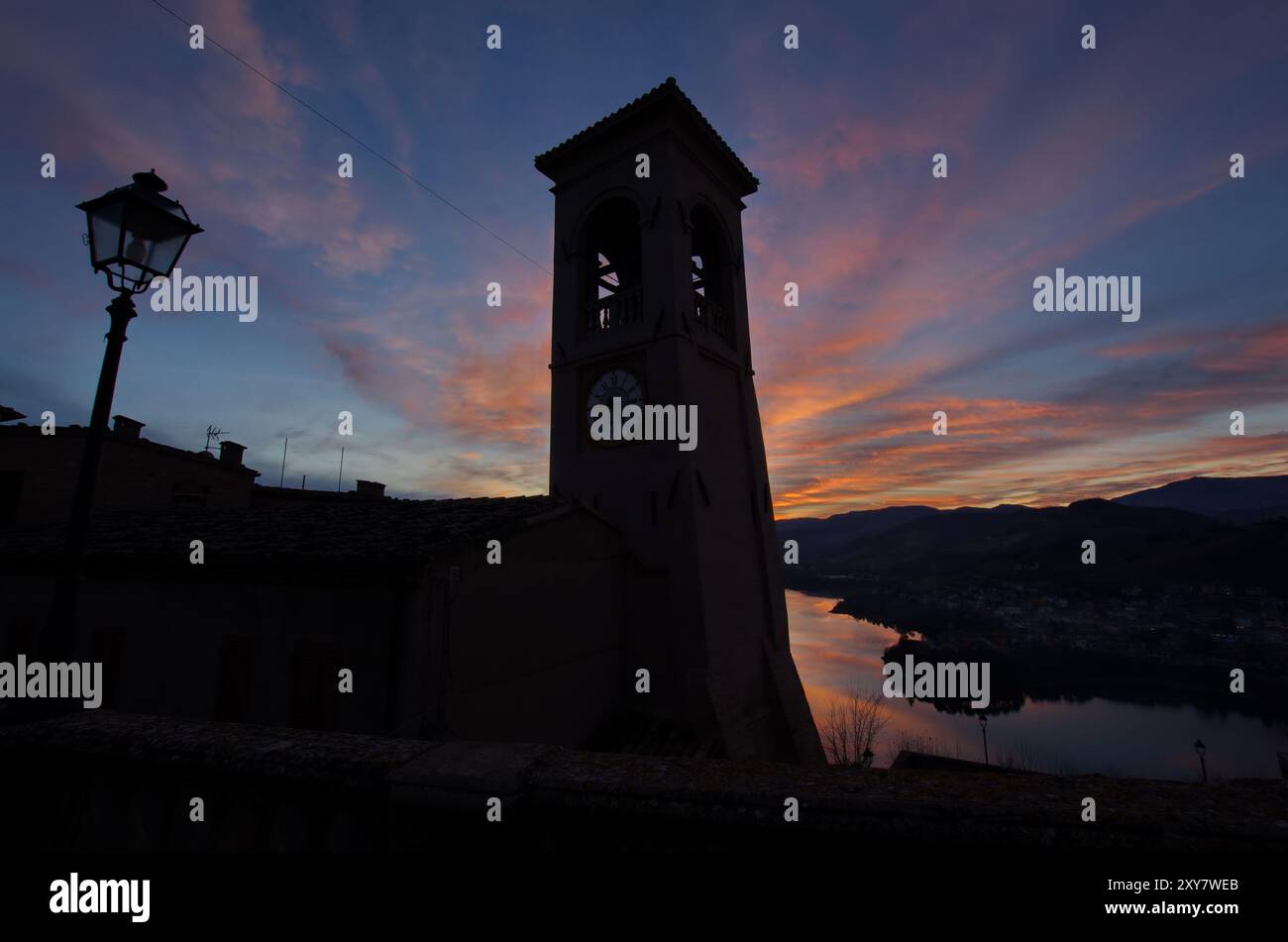 Panorama del lago di Mercatale, visto dalla piazza dell'orologio del paese di Sassocorvaro, contro un cielo scenografico al tramonto Foto Stock