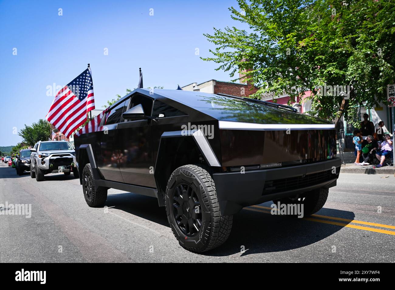 Veicolo elettrico Tesla Cybertruck e bandiera americana a barre, Vermont, parata dell'Heritage Festival, New England, Stati Uniti. Foto Stock