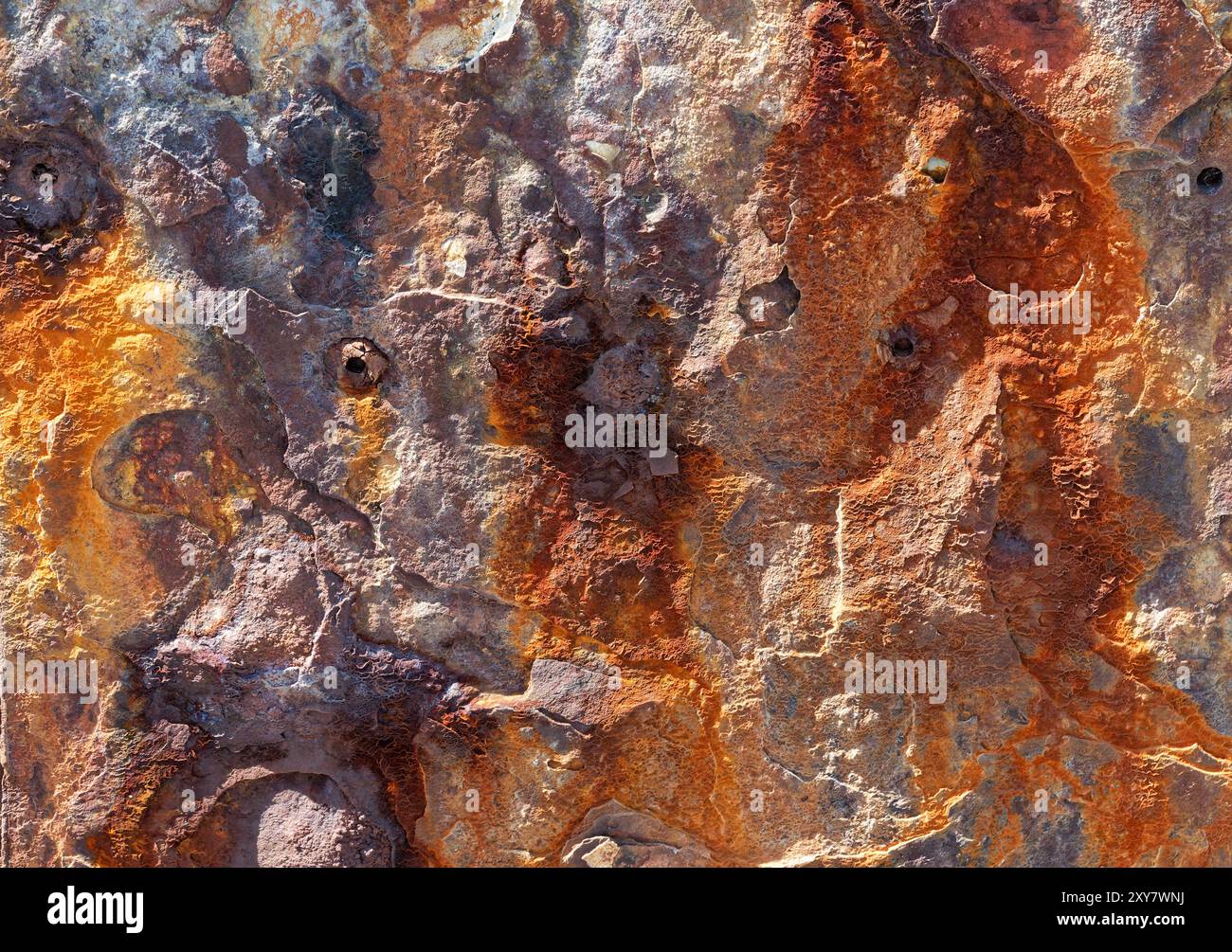 Primo piano di un muro di pietra macchiata di ferro che crea una forma astratta irregolare Foto Stock