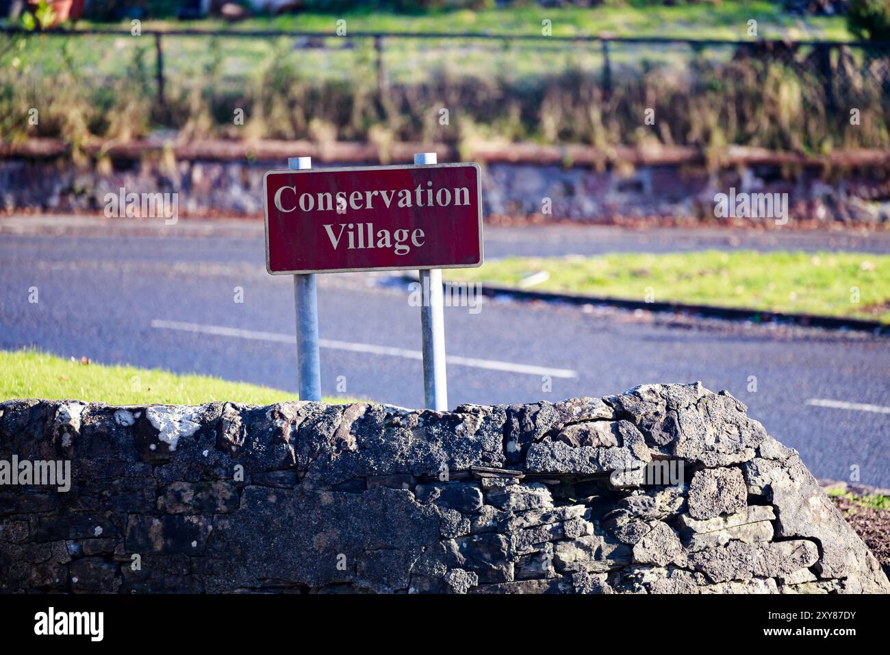 Cartello del villaggio di conversazione all'ingresso del villaggio di Cardross, il cartello mostra il tempo di muffa verde, muffa verde, muffa verde o alghe Foto Stock