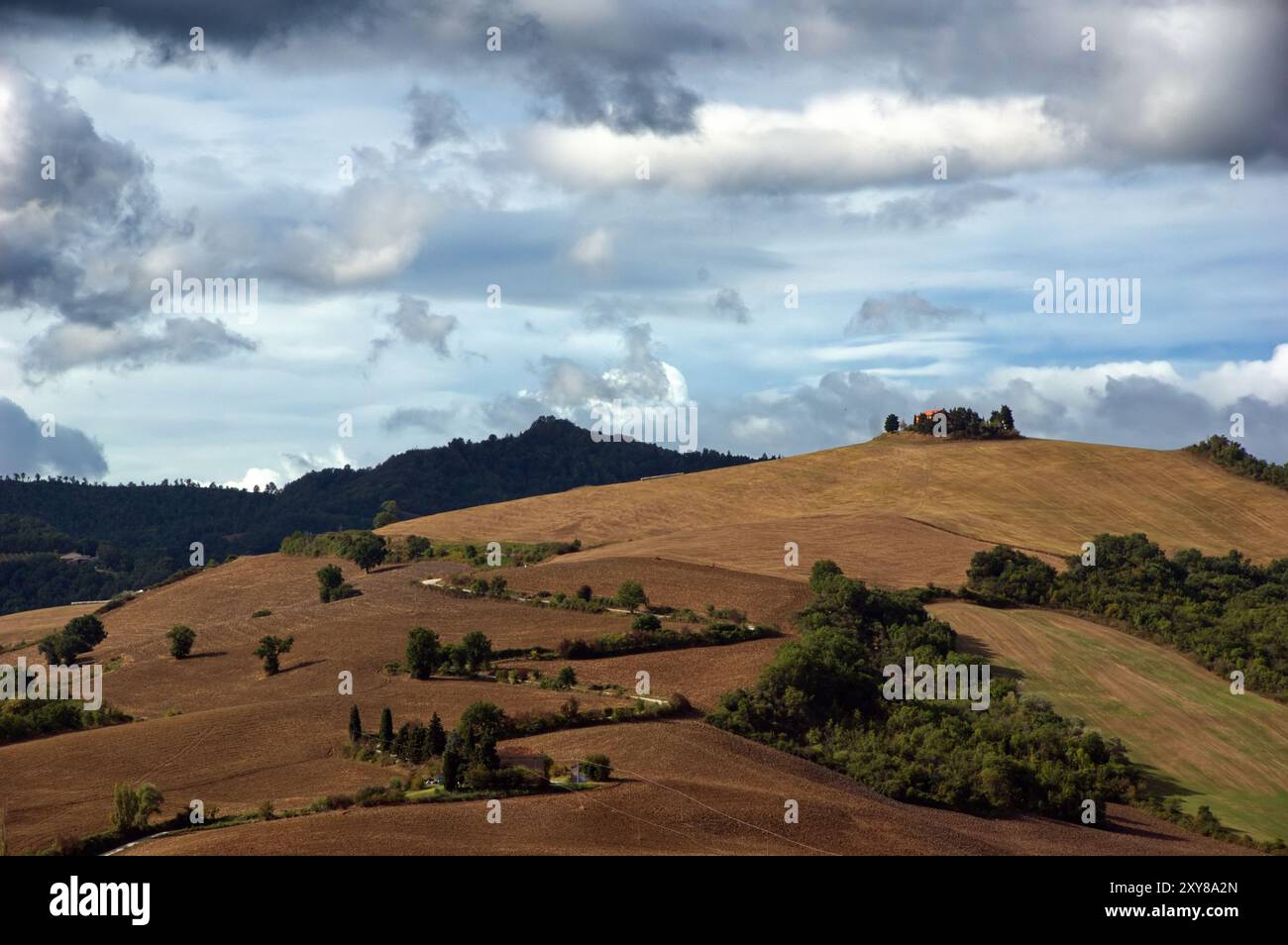 Vista in lontananza di una strada su una collina sotto il cielo nuvoloso Foto Stock