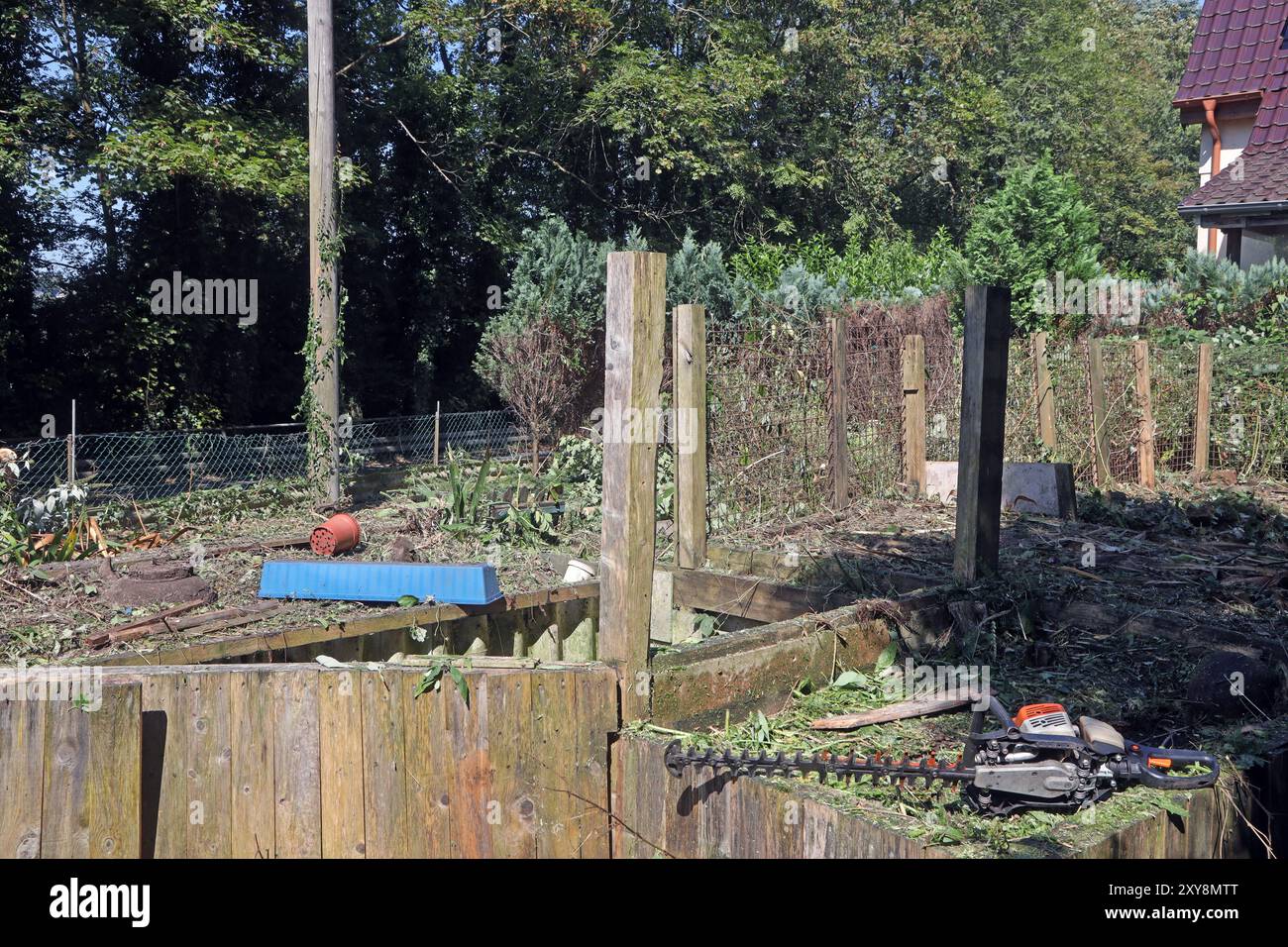 Ehemalige Gärten im Siedlungsraum Ein verfallener und verwilderter Garten wird zu einem Schandfleck und unter erheblicher Arbeit entrümpelt und neu gestaltet. *** Ex giardini nell'area residenziale Un giardino fatiscente e ricoperto diventa un palato e viene ripulito e ridisegnato con notevoli lavori Foto Stock