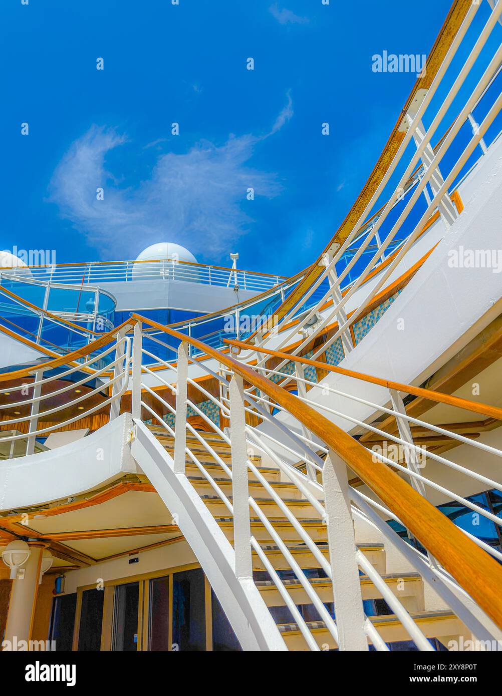 Ammira le scale all'esterno su una nave da crociera. Ammira il cielo blu con le nuvole sopra. Vedere ringhiere bianche dipinte pulite sui ponti. Nave pronta. Foto Stock