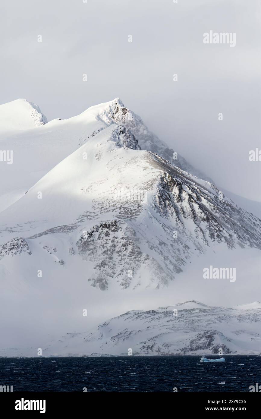 Vista delle montagne innevate che circondano lo stretto Antartico, Antartide. Foto Stock