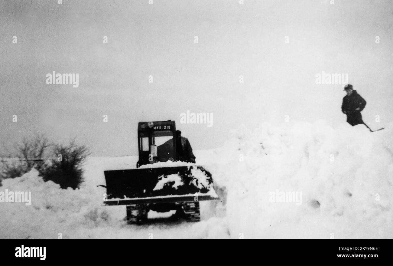 Un Bulldozer/Crawler cingolato elimina la neve da una strada di campagna vicino a Dodburn, Hawick durante l'inverno estremo del 1963. Scottish Borders, Regno Unito. Foto Stock