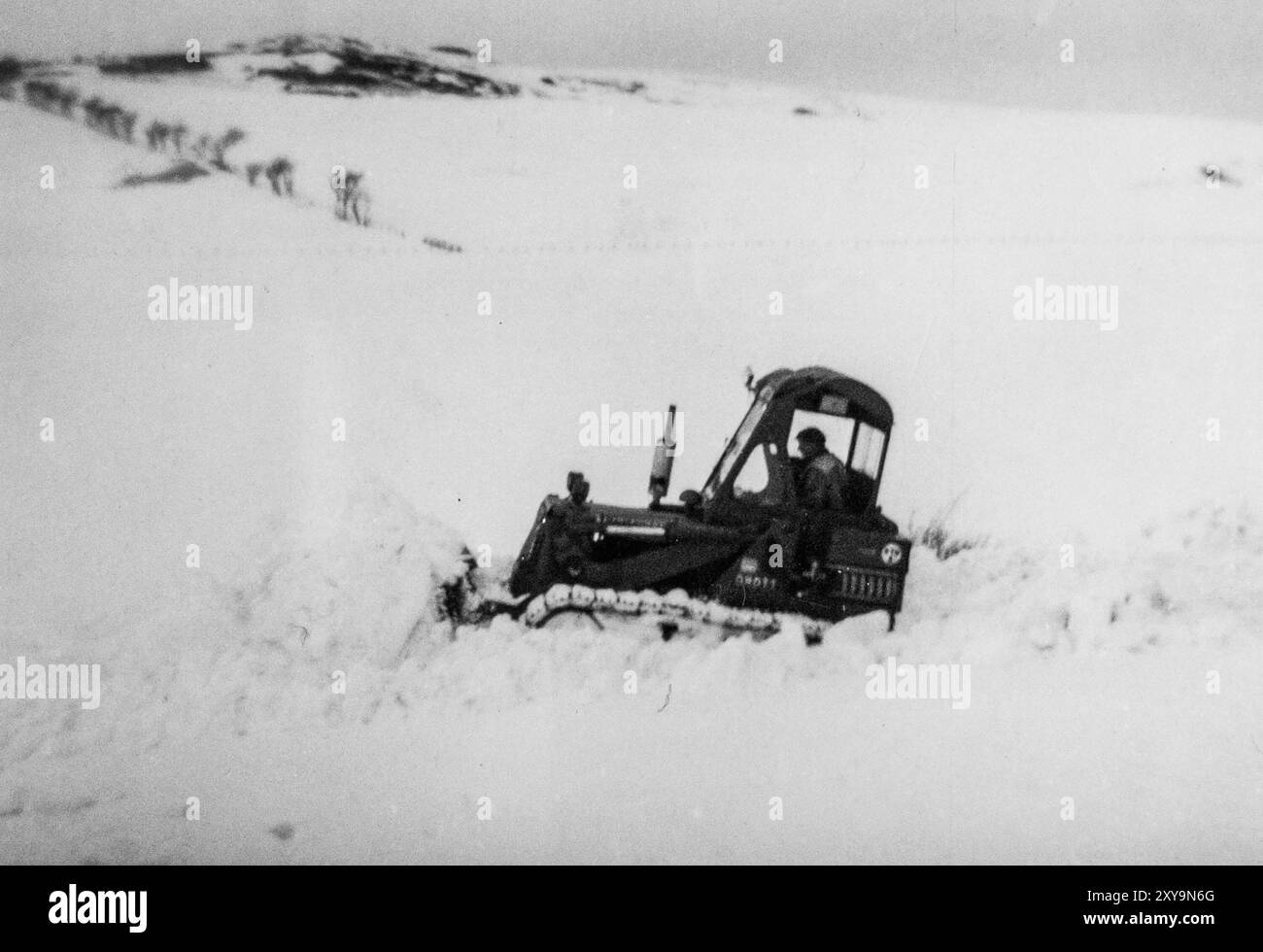 Un Bulldozer/Crawler cingolato elimina la neve da una strada di campagna vicino a Dodburn, Hawick durante l'inverno estremo del 1963. Scottish Borders, Regno Unito. Foto Stock