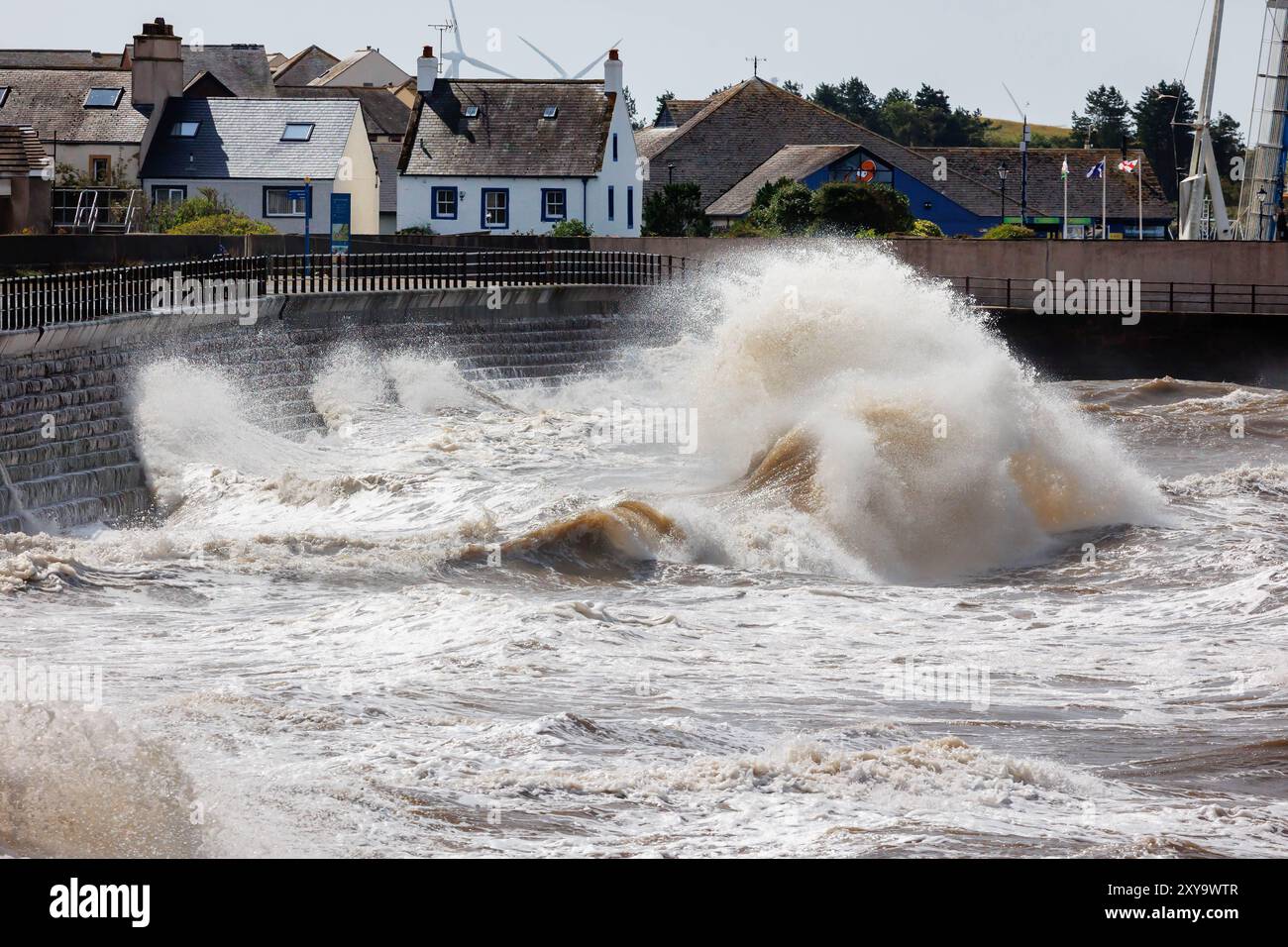 Mari tempestosi che creano enormi onde contro gli scalini all'ingresso del porto di Maryport Foto Stock