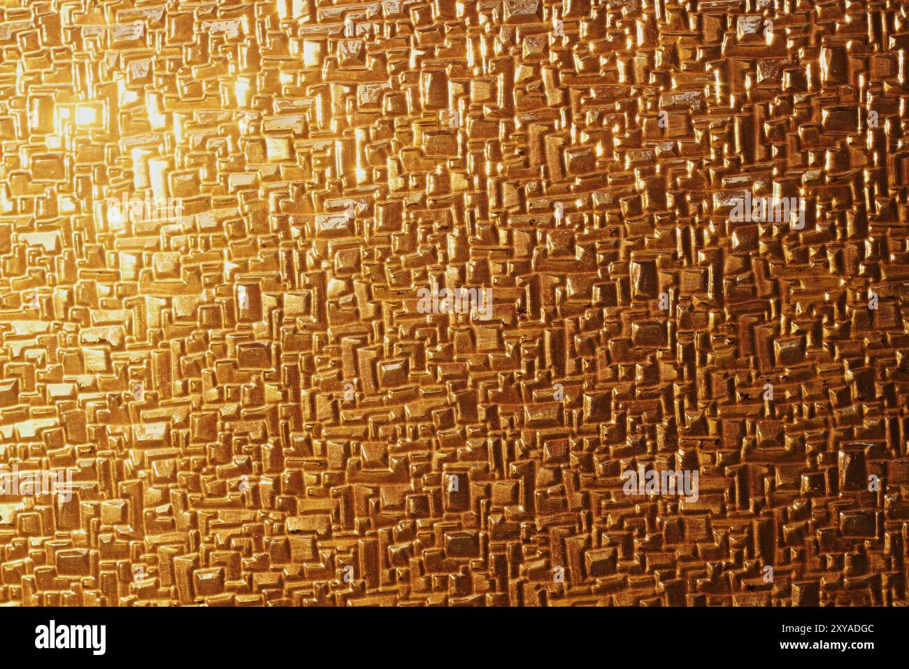 Un primo piano di vetro lucido che riflette le calde sfumature dorate della luce del tramonto. La trama astratta evidenzia l'interazione tra luce e superficie, creato Foto Stock