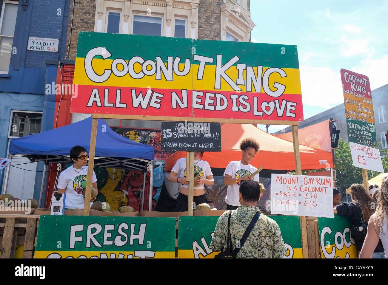 Londra, Regno Unito. Le bancarelle fiancheggiano il percorso del Carnevale di Notting Hill, che offre un'appetitosa scorta di pollo strapazzato, acqua di cocco, punch al rum e molto altro. Foto Stock