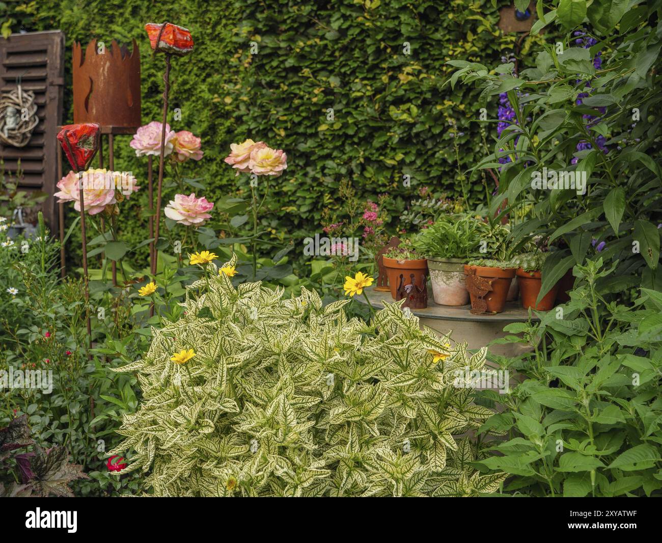 Lussureggiante giardino fiorito con vari fiori, arbusti verdi ed elementi decorativi, borken, muensterland, germania Foto Stock