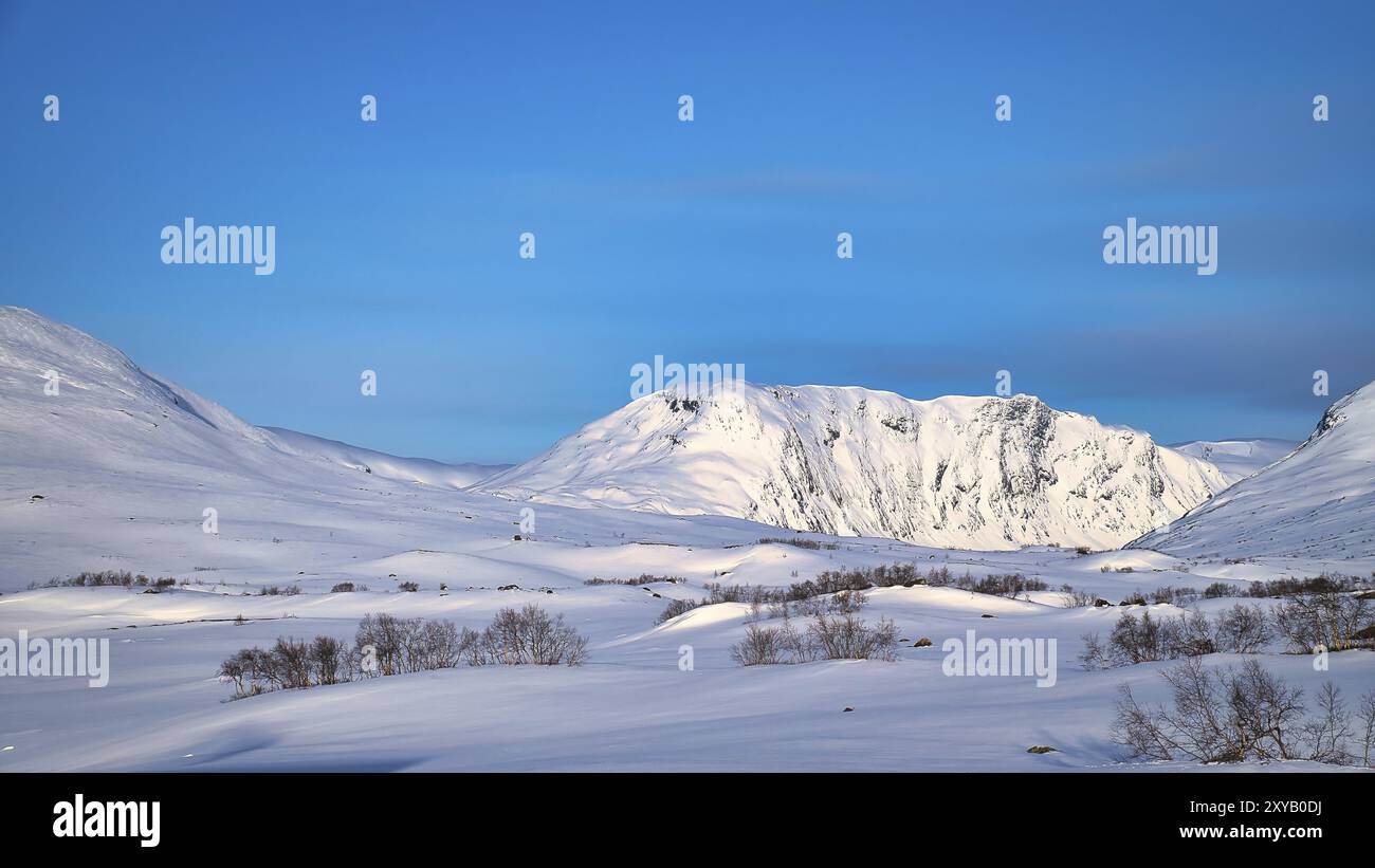 Alte montagne norvegesi nella neve. Montagne coperte di neve. Paesaggio innevato in Scandinavia Foto Stock