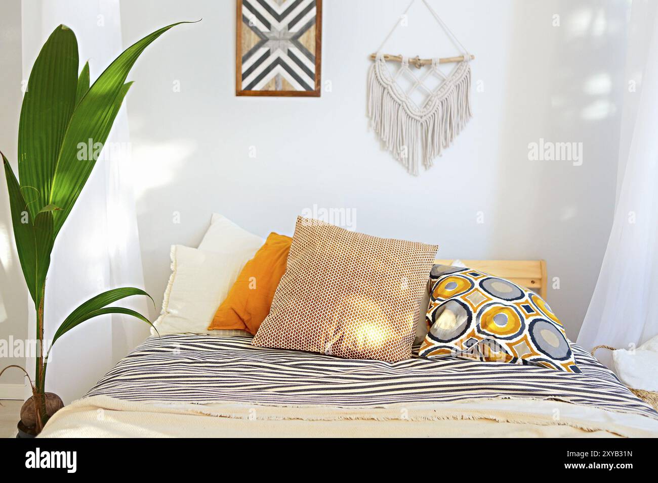 Bianco e beige camera da letto in stile Boho con macrame sulla parete Foto Stock