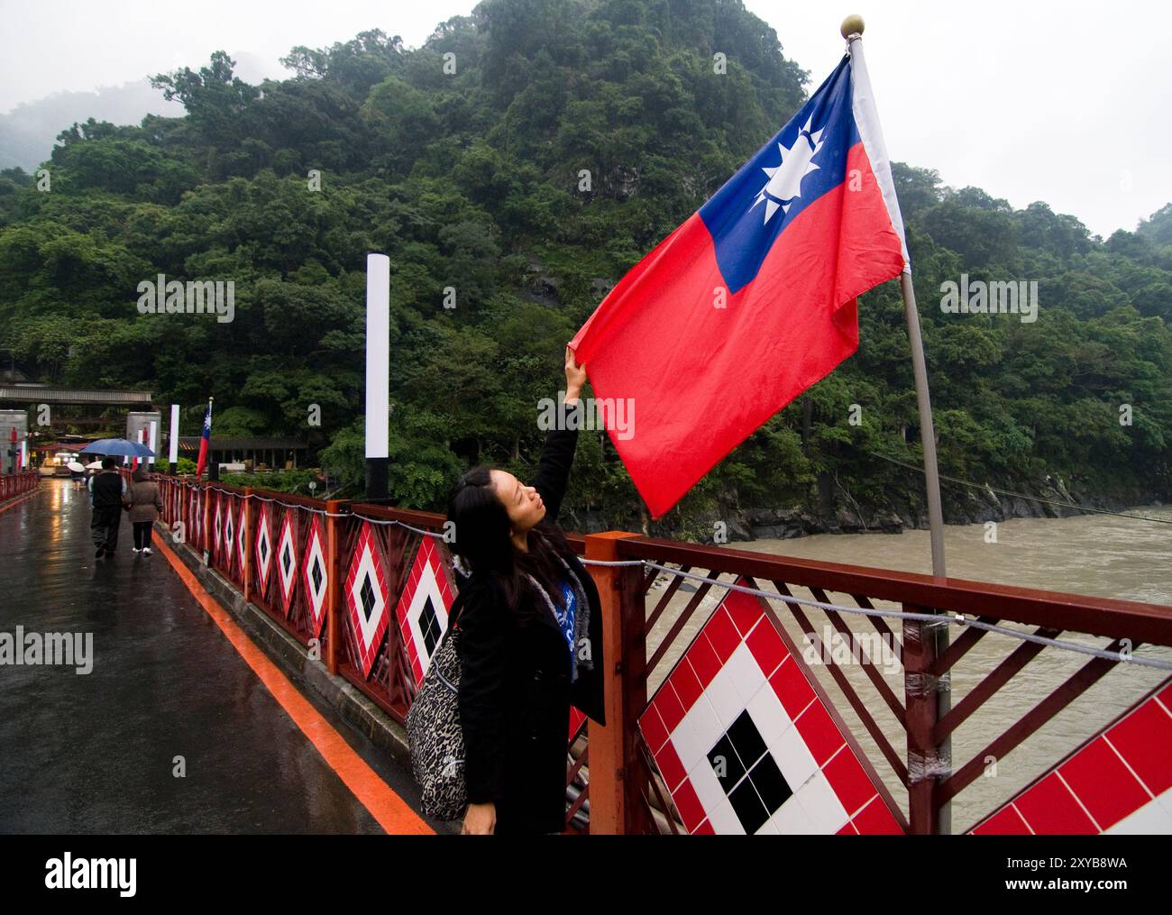 Una donna taiwanese in piedi accanto alla bandiera di Taiwan. Foto Stock