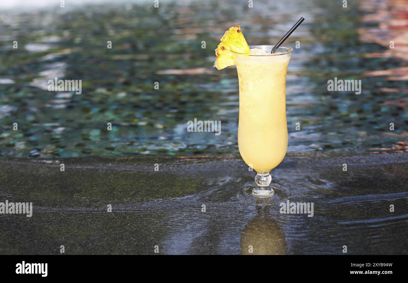 Bicchiere di cocktail pinacolada permanente sulla piscina listello in un resort tropicale Foto Stock