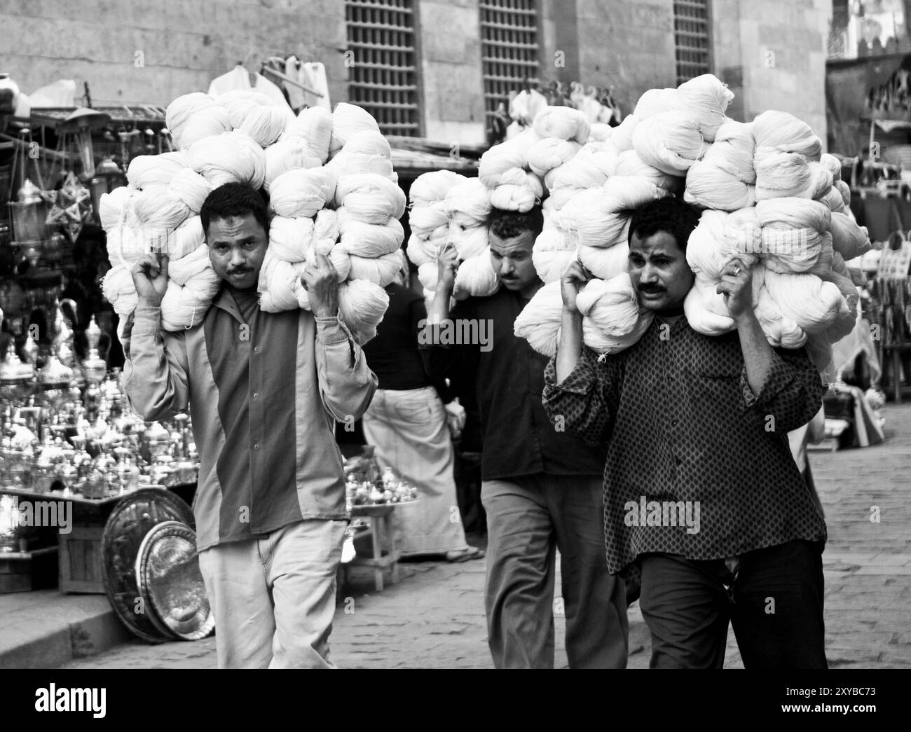 Uomini egiziani che trasportano filati nel colorato mercato islamico del Cairo, in Egitto. Foto Stock