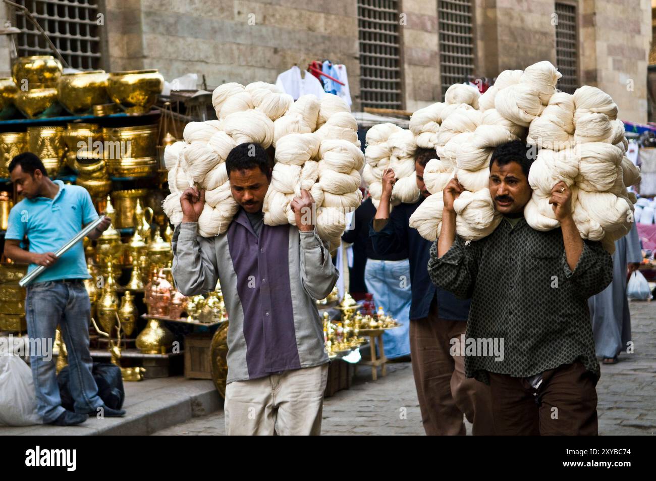 Uomini egiziani che trasportano filati nel colorato mercato islamico del Cairo, in Egitto. Foto Stock
