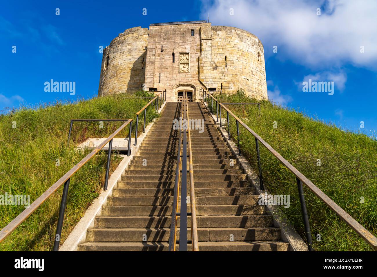 Clifford's Tower a York, in Inghilterra, in una giornata di sole senza gente. Fortezza reale medievale costruita nel 1068, il castello di York è un punto di riferimento storico. Foto Stock