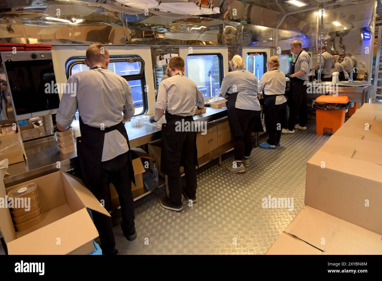 I volontari di Food Train confezionano pasti caldi per la distribuzione Foto Stock