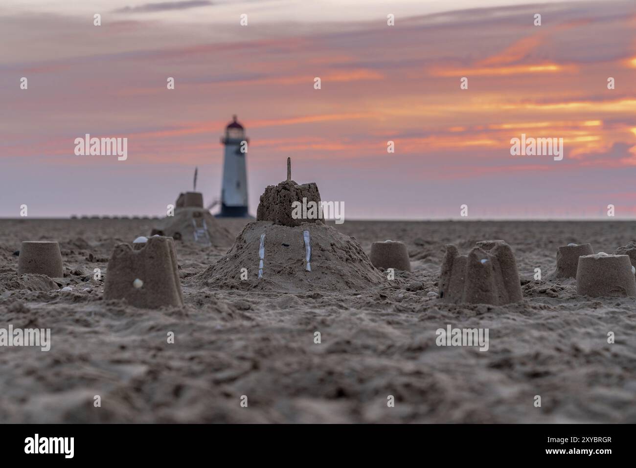 Il Sandcastles On la spiaggia, con serata nuvole e punto di Ayr il faro in background, vicino Talacre, Flintshire, Wales, Regno Unito Foto Stock