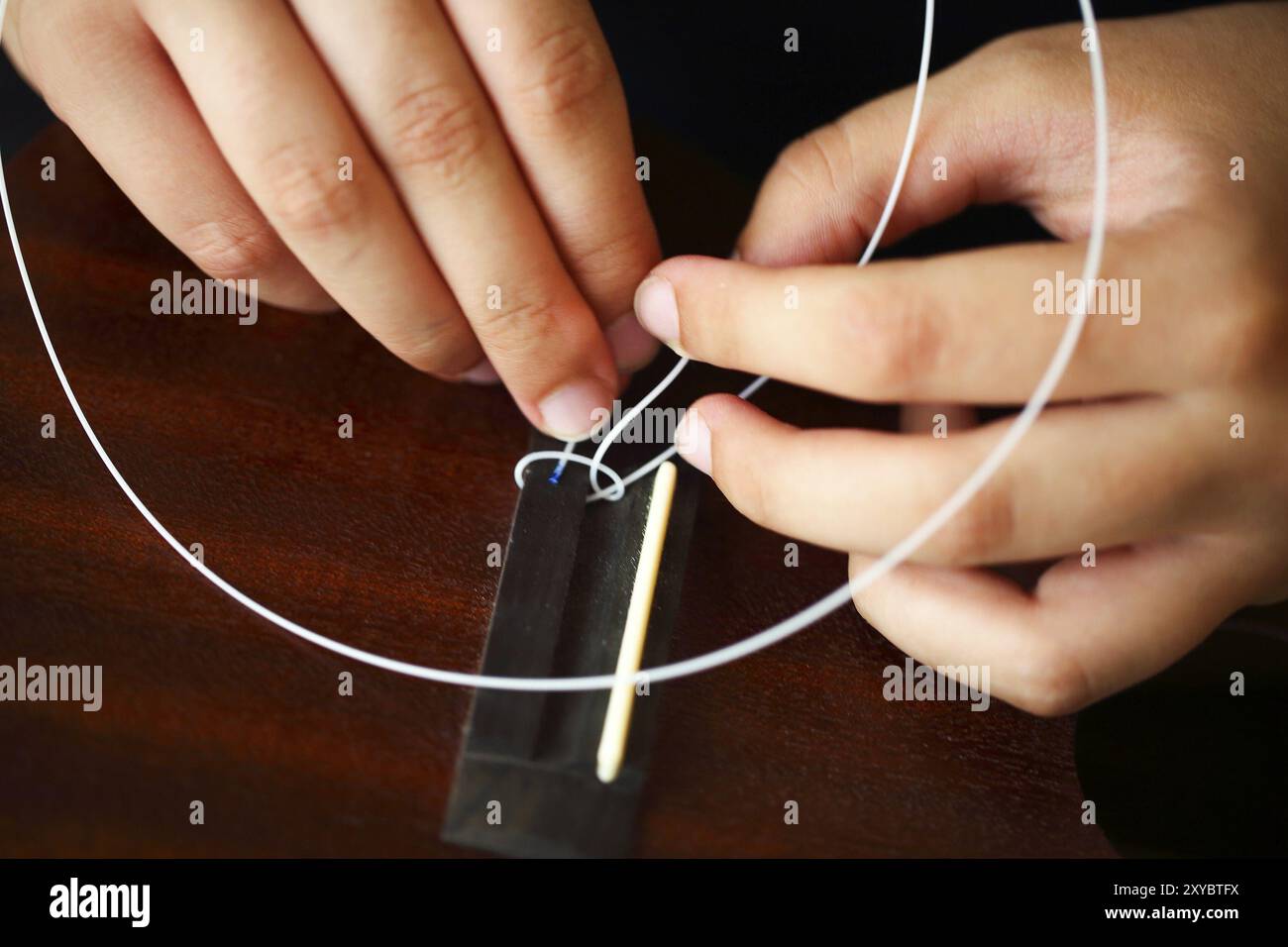 Tuning la stringa di ukulele, mani umane, primo piano. Processo di modifica della stringa di ukulele Foto Stock Tuning la stringa di ukulele, mani umane, primo piano. Processo di modifica della stringa di ukulele Foto Stock