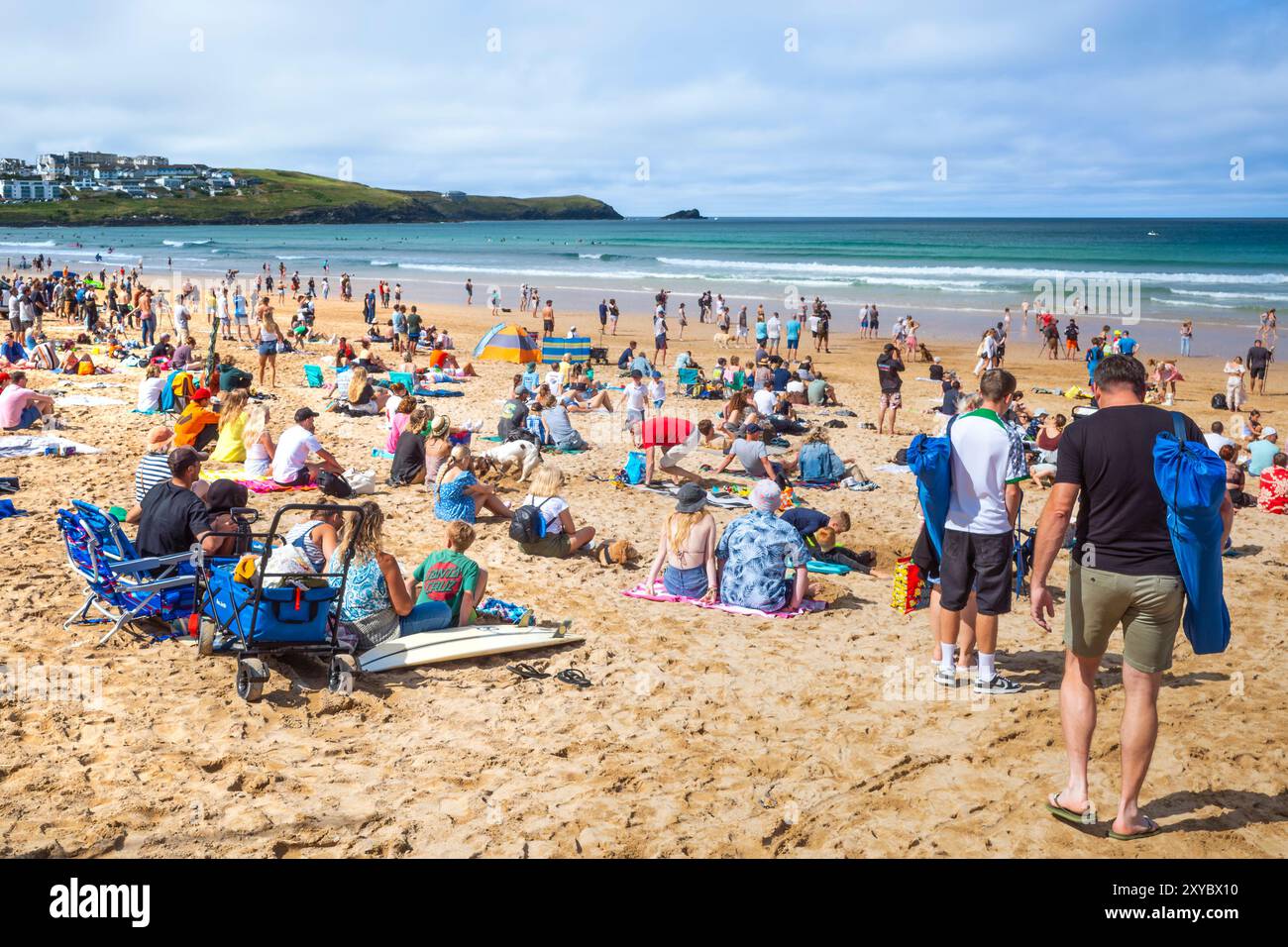 Turisti che si godono il sole estivo sull'iconica spiaggia Fistral di Newquay, in Cornovaglia, nel Regno Unito. Foto Stock