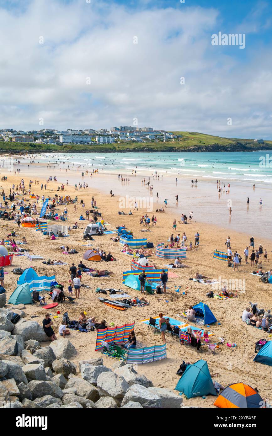 Turisti che si godono il sole estivo sull'iconica spiaggia Fistral di Newquay, in Cornovaglia, nel Regno Unito. Foto Stock