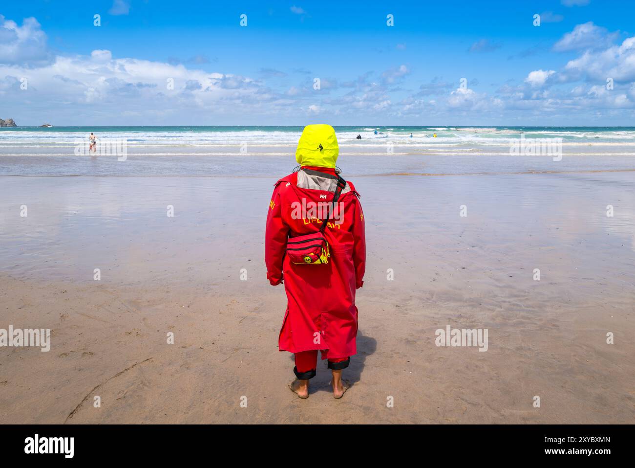 Un bagnino RNLI in piedi a guardare le persone in mare a Towan Beach a Newquay, in Cornovaglia, nel Regno Unito. Foto Stock