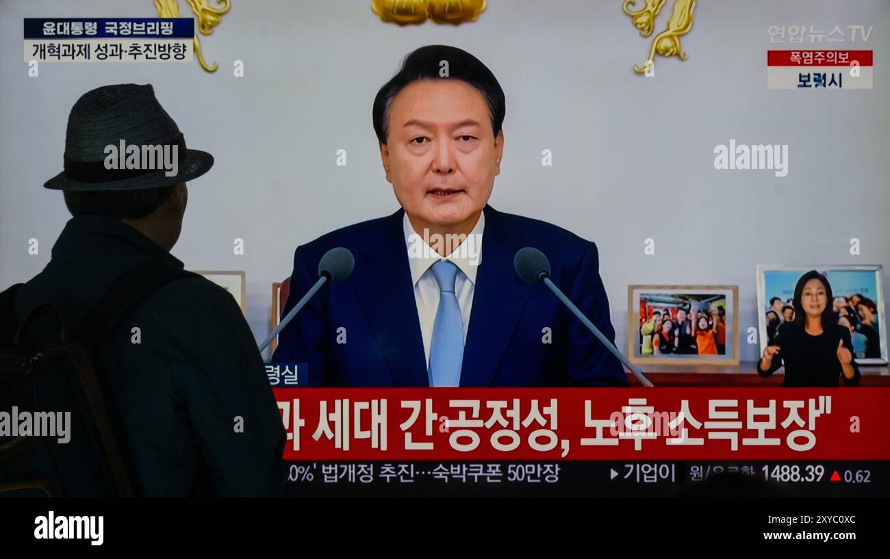 Una trasmissione televisiva di Yonhapnews 24 ore su 24 alla stazione ferroviaria di Yongsan trasmette il presidente sudcoreano Yoon Suk Yeol mentre tiene un discorso durante un briefing politico sugli affari di stato e una conferenza stampa presso l'ufficio presidenziale di Seoul, Corea del Sud. Il presidente sudcoreano Yoon Suk Yeol ha dichiarato nell'agosto 29 che il governo perseguirà gradualmente l'aumento dei premi pensionistici per le generazioni più giovani e di mezza età a un ritmo diverso, oltre a introdurre meccanismi per migliorare la stabilità finanziaria del sistema pensionistico. Yoon ha delineato una serie di misure di riforma durante un briefing politico come Sud Foto Stock