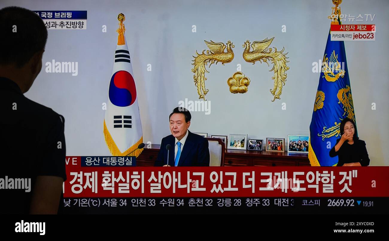 Una trasmissione televisiva di Yonhapnews 24 ore su 24 alla stazione ferroviaria di Yongsan trasmette il presidente sudcoreano Yoon Suk Yeol mentre tiene un discorso durante un briefing politico sugli affari di stato e una conferenza stampa presso l'ufficio presidenziale di Seoul, Corea del Sud. Il presidente sudcoreano Yoon Suk Yeol ha dichiarato nell'agosto 29 che il governo perseguirà gradualmente l'aumento dei premi pensionistici per le generazioni più giovani e di mezza età a un ritmo diverso, oltre a introdurre meccanismi per migliorare la stabilità finanziaria del sistema pensionistico. Yoon ha delineato una serie di misure di riforma durante un briefing politico come Sud Foto Stock