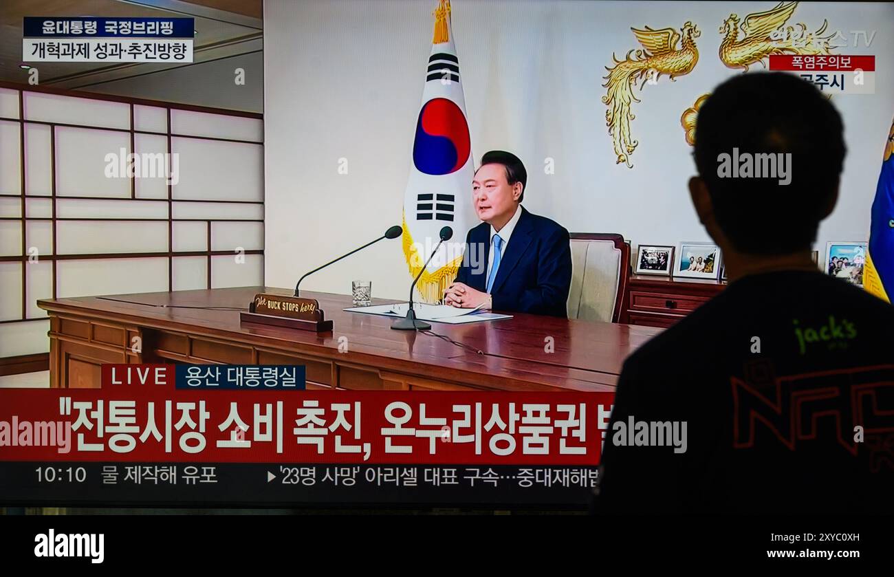 Una trasmissione televisiva di Yonhapnews 24 ore su 24 alla stazione ferroviaria di Yongsan trasmette il presidente sudcoreano Yoon Suk Yeol mentre tiene un discorso durante un briefing politico sugli affari di stato e una conferenza stampa presso l'ufficio presidenziale di Seoul, Corea del Sud. Il presidente sudcoreano Yoon Suk Yeol ha dichiarato nell'agosto 29 che il governo perseguirà gradualmente l'aumento dei premi pensionistici per le generazioni più giovani e di mezza età a un ritmo diverso, oltre a introdurre meccanismi per migliorare la stabilità finanziaria del sistema pensionistico. Yoon ha delineato una serie di misure di riforma durante un briefing politico come Sud Foto Stock