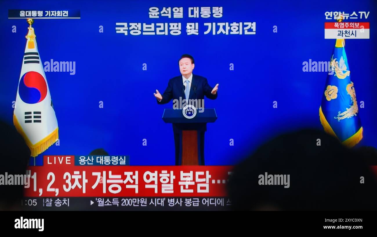 Una trasmissione televisiva di Yonhapnews 24 ore su 24 alla stazione ferroviaria di Yongsan trasmette il presidente sudcoreano Yoon Suk Yeol mentre tiene un discorso durante un briefing politico sugli affari di stato e una conferenza stampa presso l'ufficio presidenziale di Seoul, Corea del Sud. Il presidente sudcoreano Yoon Suk Yeol ha dichiarato nell'agosto 29 che il governo perseguirà gradualmente l'aumento dei premi pensionistici per le generazioni più giovani e di mezza età a un ritmo diverso, oltre a introdurre meccanismi per migliorare la stabilità finanziaria del sistema pensionistico. Yoon ha delineato una serie di misure di riforma durante un briefing politico come Sud Foto Stock