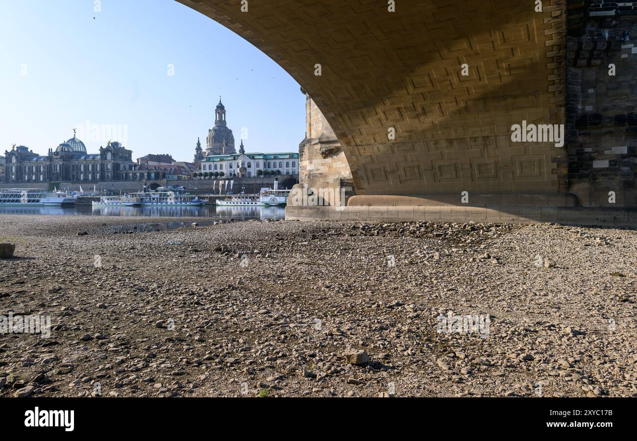 Dresda, Germania. 29 agosto 2024. Le sponde dell'Elba sotto il Ponte di Augusto, di fronte alla città Vecchia sullo sfondo con la Frauenkirche, sono asciutte. Il livello dell'Elba a Dresda è attualmente di 80 centimetri. Crediti: Robert Michael/dpa/Alamy Live News Foto Stock