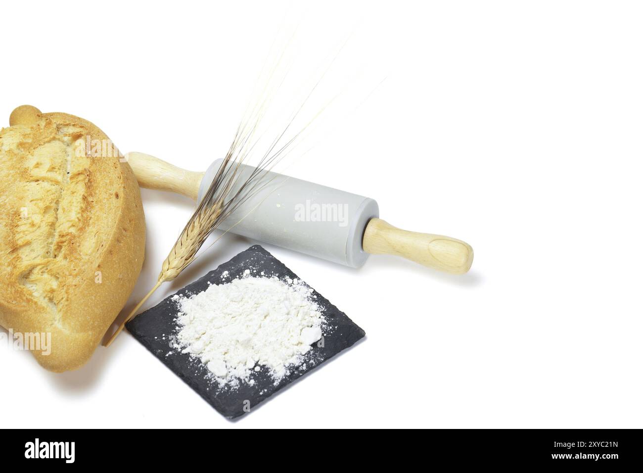 Pane soffice con farina, orecchie di grano e un mattarello isolato su sfondo bianco e spazio di copia Foto Stock