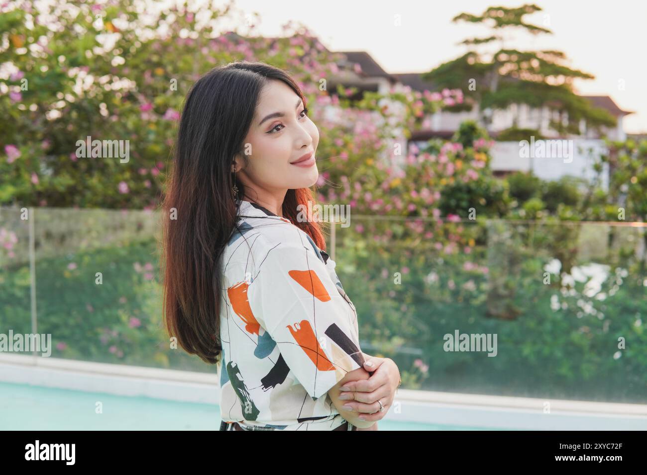 La giovane donna asiatica felice sorride e posa per un'immagine in un tetto. Concetto di felicità e rilassamento, mentre la donna sta godendo il Golden hou Foto Stock