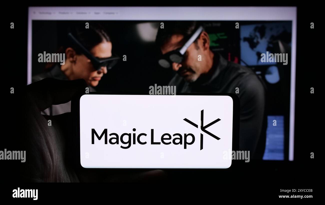 Persona che detiene un cellulare con il logo della società di visualizzazione di realtà aumentata statunitense Magic Leap Inc. Di fronte alla pagina Web aziendale. Mettere a fuoco il display del telefono. Foto Stock