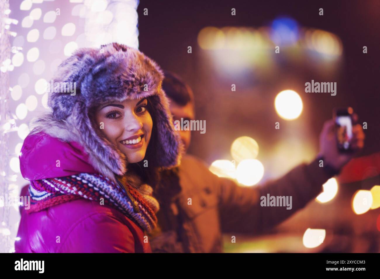 Coppia felice facendo una selfie con un albero di natale a sfondo Foto Stock