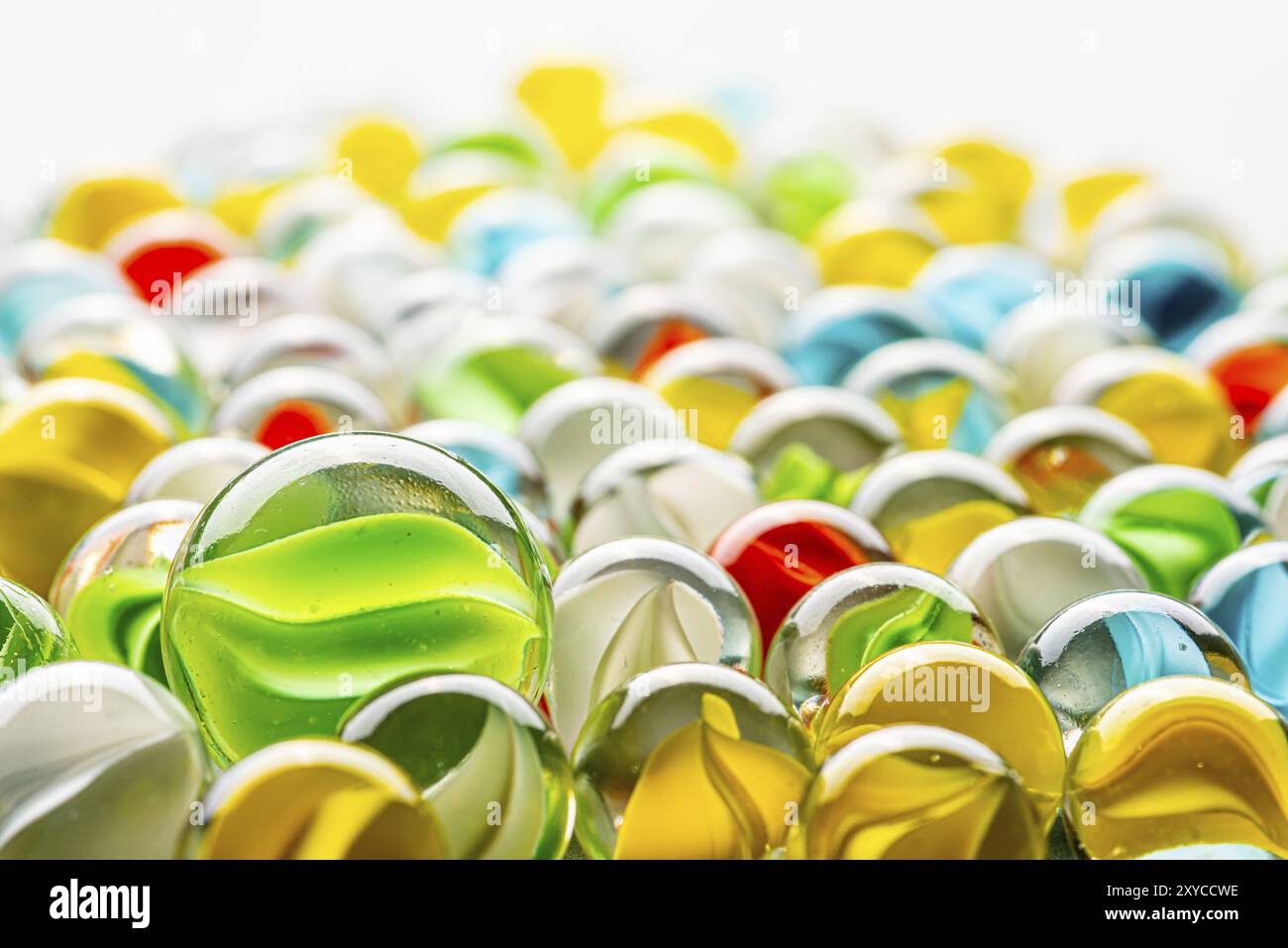 Marmi di vetro gialli, verdi, blu e rossi su un tavolo Foto Stock