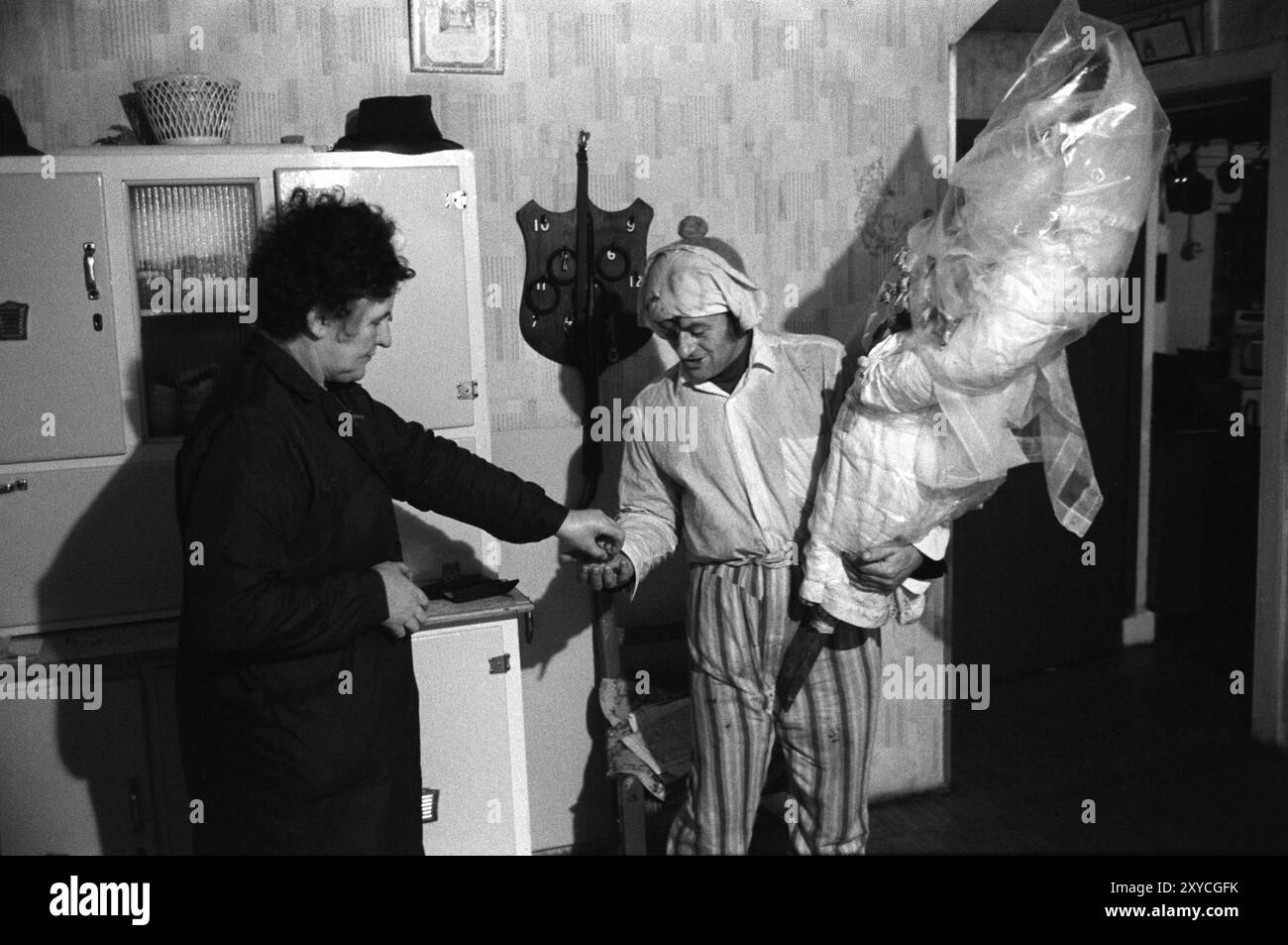 Biddy Boys, tradizionale festa annuale del folclore irlandese. Una festa per celebrare il Santo celtico, St Brigit o St Brigid. Un'effigie del Santo, nota come Biddy, viene portata in una casa, dove si svolgeranno musica e balli. L'uomo che trasporta il Biddy raccoglie una piccola somma di denaro alla fine della visita dalla signora della casa, questo porta fortuna alla famiglia per l'anno successivo. Se non ci sono soldi, la signora dà una spilla ai Biddy Boys. Killorglin, Contea di Kerry, Irlanda del Sud febbraio 1972 1970s Eire HOMER SYKES Foto Stock